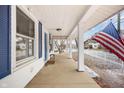 Charming front porch of a home with a swing, an American flag, and bright blue shutters and door at 122 S Green St, Brownsburg, IN 46112