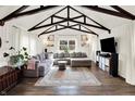 Spacious living room with exposed beams, large sectional sofa, and stylish rug, perfect for Gathering gatherings at 129 N Sadlier Dr, Indianapolis, IN 46219