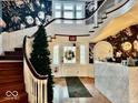 Elegant foyer with a curved staircase, marble reception desk, and decorative wallpaper at 1300 W University Ave, Muncie, IN 47303