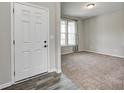 Home entryway with a white door and light gray walls; a doorway leads to a carpeted room with natural light at 13115 N Departure W Blvd, Camby, IN 46113