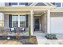 Inviting front porch with a seating area and a decorative front door with a wreath and a welcome sign at 13115 N Departure W Blvd, Camby, IN 46113