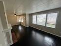 Bright living room with dark hardwood flooring, a fireplace, and lots of natural light at 1925 N Leland Ave, Indianapolis, IN 46218
