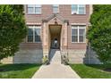 Building entrance featuring stone steps, potted plants, and a well-maintained lawn at 450 E Ohio St # Apt 118, Indianapolis, IN 46204