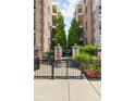 Gated entrance to the building featuring a brick facade and manicured flowerbeds and landscaping at 450 E Ohio St # Apt 118, Indianapolis, IN 46204