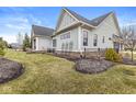 Well-maintained backyard with a black metal fence, green grass, landscaping, and partial view of the home at 4722 Wellswood, Carmel, IN 46033