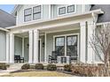 Inviting front porch featuring white columns, rocking chairs, and manicured landscaping, enhancing curb appeal at 4722 Wellswood, Carmel, IN 46033