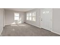 Bright living room with multiple windows and neutral carpet at 518 E College Ave, Brownsburg, IN 46112