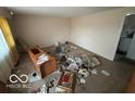 Living room featuring worn carpet, basic walls, and showing substantial deferred maintenance at 5834 42Nd St, Indianapolis, IN 46226
