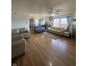 Bright and airy living room with hardwood floors, a ceiling fan, large windows, and a cozy fireplace at 6817 Everbloom Ln, Indianapolis, IN 46217