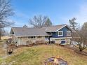 Charming two-story home with stone accents, blue siding, and a cozy fire pit at 12166 Bray Rd, Mooresville, IN 46158
