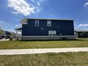 Side exterior view of a two-story home with blue siding and well-kept lawn at 1256 Turner Trace N Pl, Avon, IN 46123
