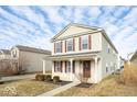 Two-story home with light siding, red shutters, and a cozy covered front porch at 12884 Courage Xing, Fishers, IN 46037