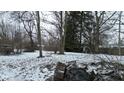 Snow-covered backyard with large bare trees and visible debris on an overcast winter day at 1621 Indiana Ave, Anderson, IN 46012