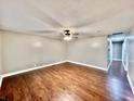 Spacious living room boasts sleek hardwood floors, neutral paint, updated ceiling fan, and plenty of natural light at 1820 N Dequincy St, Indianapolis, IN 46218