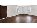 Bright living room featuring refinished hardwood floors and two windows for ample natural light at 3636 Lasalle St, Indianapolis, IN 46218