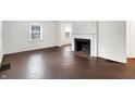 Spacious living room with refinished hardwood floors, a fireplace, and seamless flow to the dining area at 3636 Lasalle St, Indianapolis, IN 46218