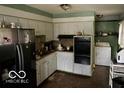 A kitchen featuring ample cabinet space, a stainless steel refrigerator, and essential appliances at 3728 Orchard Ave, Indianapolis, IN 46218