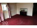 A living room with red carpet, a window covered in pink curtains, and an aquarium on a stand at 3728 Orchard Ave, Indianapolis, IN 46218