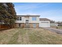 Charming two-story home featuring a brick and wood exterior, attached garage, and a well-manicured front yard at 5441 E 34Th St, Indianapolis, IN 46218