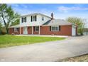 Charming two-story home featuring a well-maintained lawn, brickwork, and a driveway at 6629 N 600 W, Fairland, IN 46126