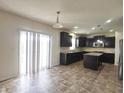 Open kitchen featuring dark cabinetry, stainless steel appliances, tiled floor and sliding door at 7027 Pinnacle Dr, Columbus, IN 47201
