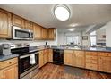 Eat-in kitchen with wood cabinets, stainless steel appliances, and a view of the dining area at 7459 Quincy Ct, Indianapolis, IN 46254