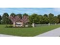 Picturesque community entrance with stone signage, lush landscaping, and a charming white fence under a blue sky at 780 James William Ln, Westfield, IN 46074