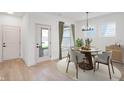 Stylish dining room with modern chandelier, round table, and white chairs set with bright light at 780 James William Ln, Westfield, IN 46074