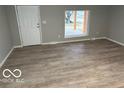 Bright living room featuring new floors and a large window for natural light at 1007 N 10Th St, Elwood, IN 46036