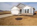 Single Gathering home featuring a two-car garage and a newly planted tree in the front yard at 1244 Fleming Dr, Greenfield, IN 46140