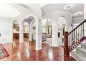 Open-concept living space with hardwood floors, arched doorways, and staircase at 14402 Wolverton Way, Fishers, IN 46037