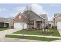 Traditional home with a well-manicured lawn, brick accents, and neutral siding at 16613 Grappa Trl, Fishers, IN 46037