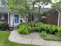 A covered front porch provides a cozy entry, enhanced with lush fern landscaping at 1701 Beech N Dr, Plainfield, IN 46168