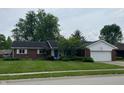 Charming brick ranch home with a well-manicured lawn and an attached two-car garage at 1701 Beech N Dr, Plainfield, IN 46168