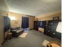 A spacious living room with carpeting, curtains, and ample bookshelf space at 20 W Elm St, Morgantown, IN 46160