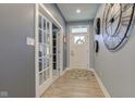 Inviting foyer features wood flooring, glass panel french doors, and decorative wall clock at 2627 Chalbury Dr, Plainfield, IN 46168