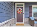 A welcoming front door with a wreath and a doormat that says 'There's no place like Mom and Papa's' at 2627 Chalbury Dr, Plainfield, IN 46168