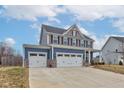 Charming home with a three-car garage, blue and gray siding with a well-maintained lawn at 2627 Chalbury Dr, Plainfield, IN 46168