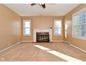 Bright living room features a classic fireplace, neutral carpet, and abundant natural light at 3533 N Grant Ave, Indianapolis, IN 46218