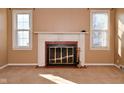 Bright living room with fireplace, neutral carpet, and two windows with coverings at 3533 N Grant Ave, Indianapolis, IN 46218