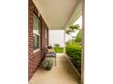 Relaxing covered front porch with decorative bench, lush greenery, and hanging flower baskets at 5650 Goodwin St, Indianapolis, IN 46234