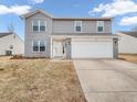Attractive two-story home with a white garage door, gray siding, and manicured front lawn at 878 Hollowood Ln, Avon, IN 46123