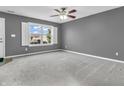 A carpeted living room features a ceiling fan, a window with shutters, and freshly painted walls at 878 Hollowood Ln, Avon, IN 46123