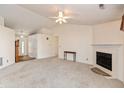 Bright living room with neutral carpet, a ceiling fan, a fireplace, and access to the front entry at 11168 Autumn Harvest Dr, Fishers, IN 46038