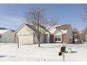 Inviting home with a two-car garage, complemented by a mature tree and a snow-covered yard at 12222 Split Granite Dr, Fishers, IN 46037