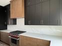 Contemporary kitchen showcasing stainless steel stove, custom cabinetry, quartz countertops, and stylish backsplash at 124 1St. Se Ave, Carmel, IN 46032