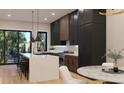 Modern kitchen with stainless steel appliances, large marble island, and dark and wood-colored cabinetry at 124 1St. Se Ave, Carmel, IN 46032