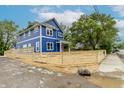 New blue construction with white trim and a red front door is protected by a wooden fence at 1305 W 23Rd St, Indianapolis, IN 46208