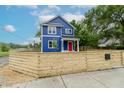 Blue home with a red door is surrounded by a wooden fence at 1305 W 23Rd St, Indianapolis, IN 46208