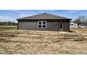 Side view of new construction home with dark siding and level backyard at 1704 N Winthrop Rd, Muncie, IN 47304
